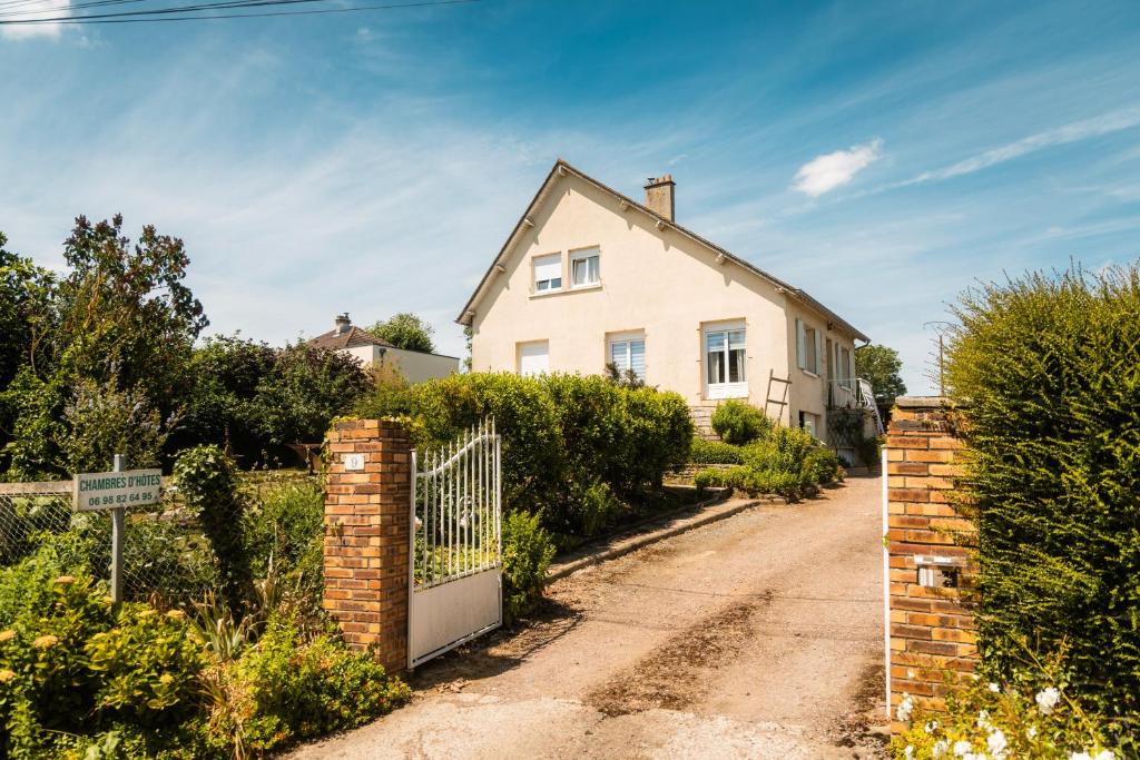 a white house with a gate on a dirt road at Chambres d'hôtes à Bavent in Bavent