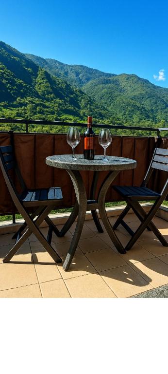 a table with a bottle of wine and two wine glasses at ValtellinaSuite in Villa di Tirano