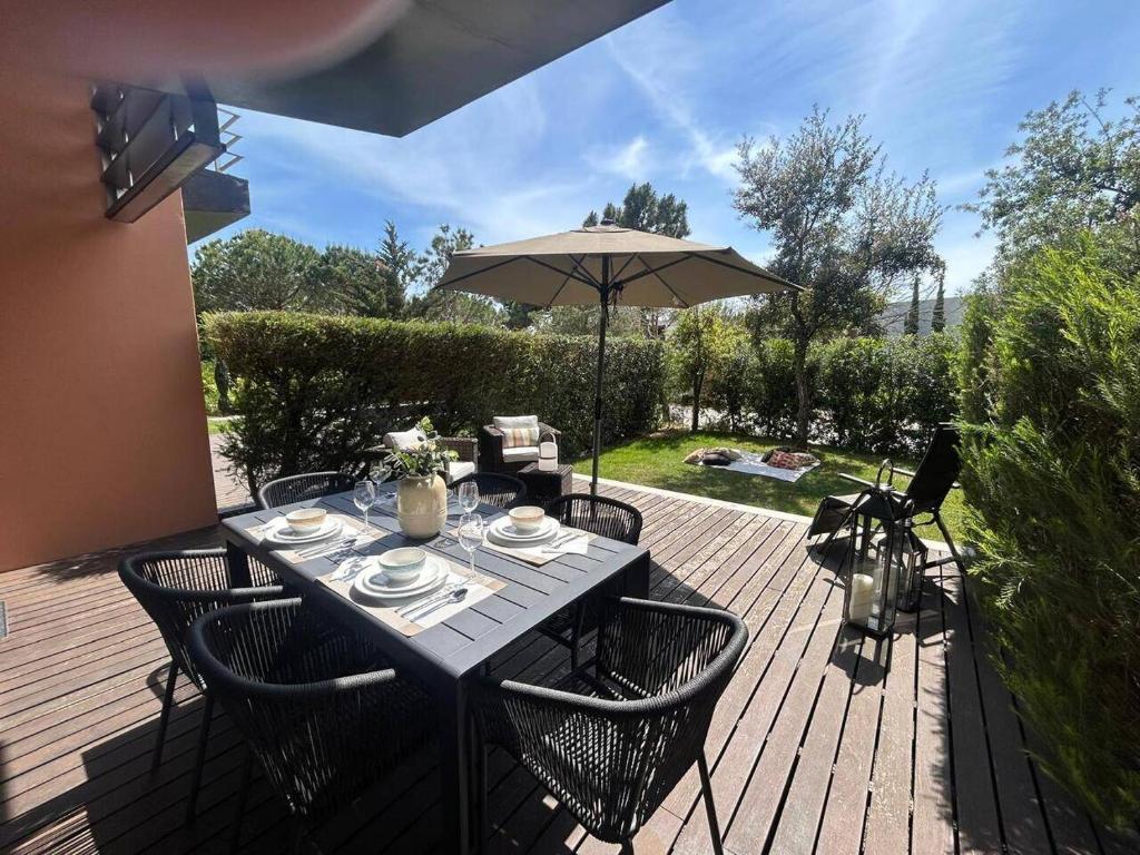 a wooden deck with a table and an umbrella at Authentic Charm C2 in Troia
