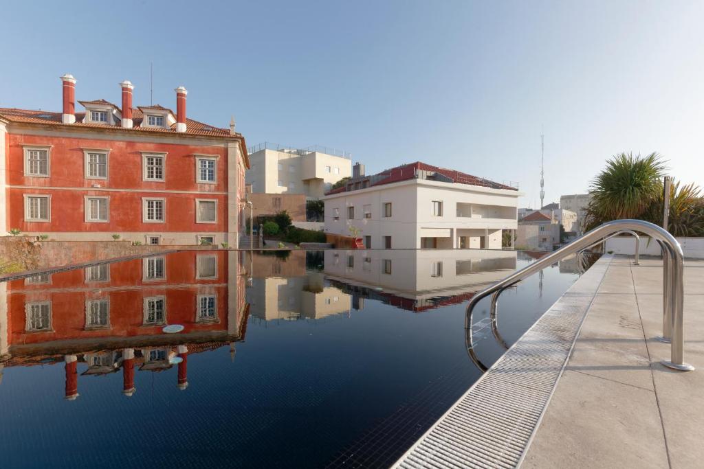 a pool of water next to some buildings and houses at Hotel Inglaterra - Charme & Boutique in Estoril