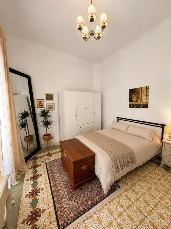 a bedroom with a bed and a dresser and a chandelier at Van Gogh Flat By La Gobernanta in Alicante
