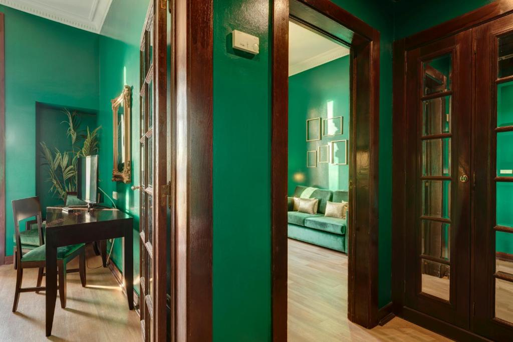 a room with green walls and a table and a couch at Hotel Inglaterra - Charme & Boutique in Estoril