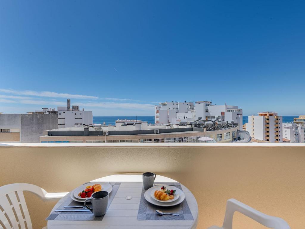 a table with two plates of food on a balcony at Apartment Mirasol by Interhome in Praia da Rocha