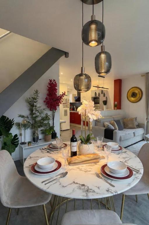 a dining room with a table with plates and glasses at Escale des Grimpeurs in Milly-la-Forêt