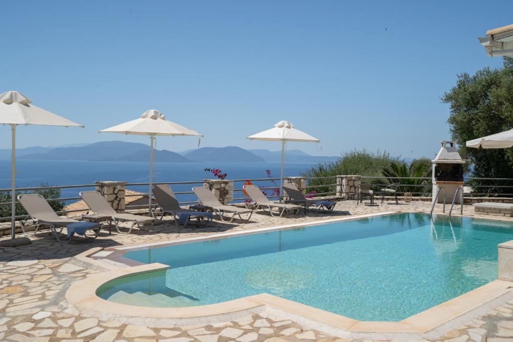 a swimming pool with chairs and umbrellas at Villa Olivia Panoramic Sea View in Lefkada