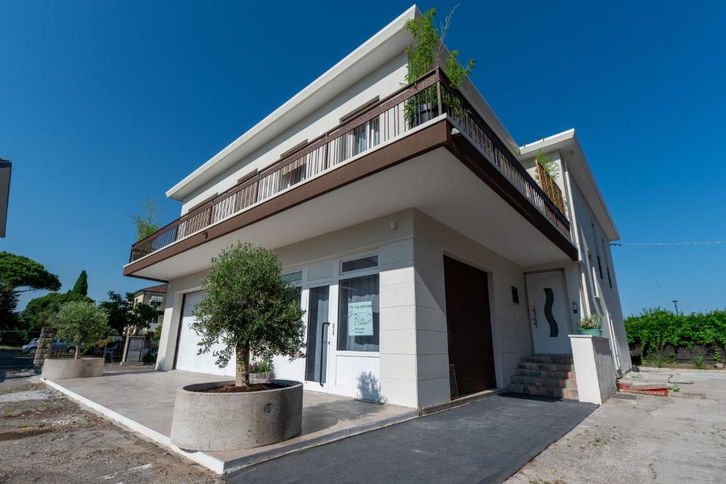 a white building with a tree in front of it at In Riva in Cavallino-Treporti
