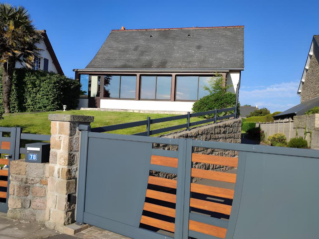a house with a gate in front of a house at Gîte 10 Couchages À Barfleur in Barfleur