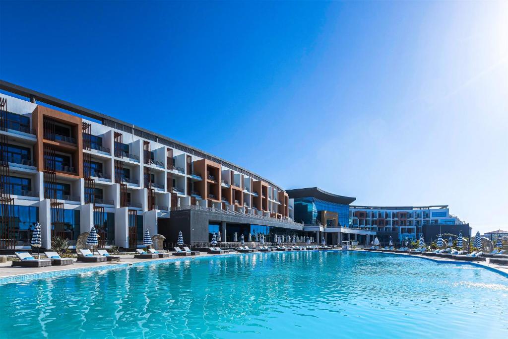 a large swimming pool in front of a hotel at Gewan White Beach Resort-New Alamein in El Alamein