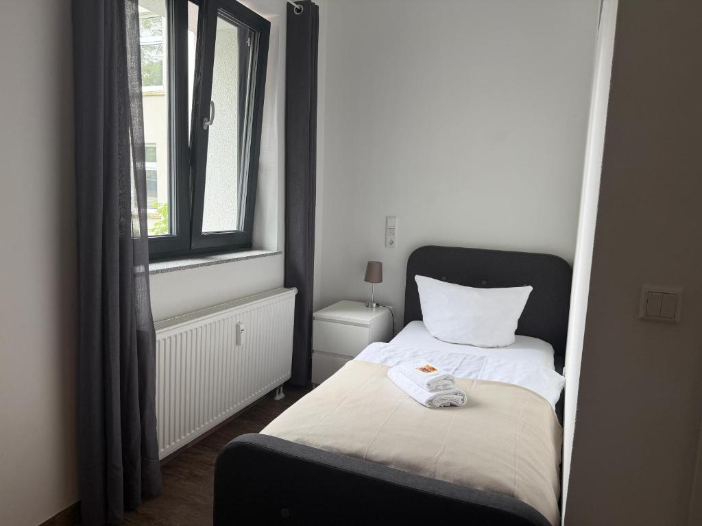a small bedroom with a bed and a window at BIELEFELD CITY APARTMENTS - komfortable Einzelzimmer und Doppelzimmer - moderne Badezimmer, schnelles WLAN, Self-Check-In in Bielefeld