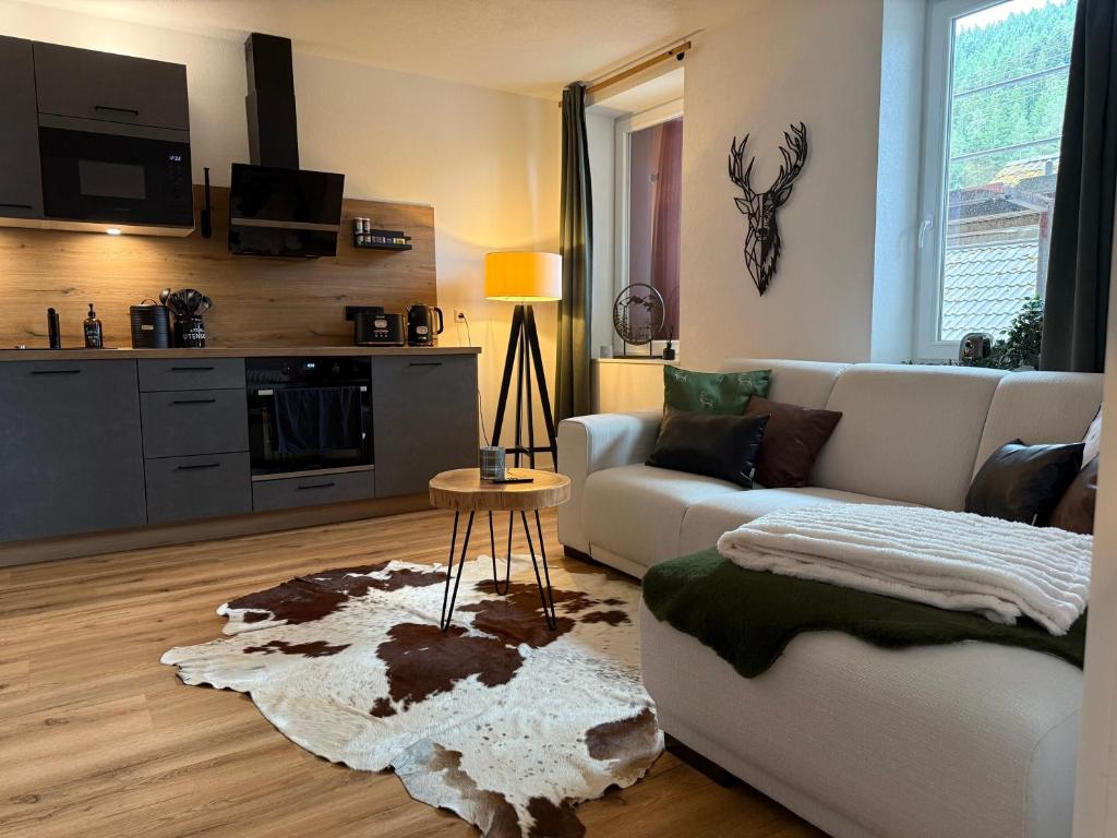 a living room with a white couch and a table at Urlaub Schwarzwaldliebe in Bad Teinach-Zavelstein