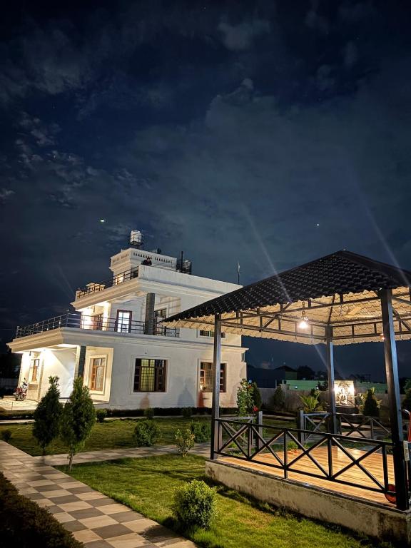 a large white house with a gambrel roof at Green Paradise 2BHK Villa with a Pool in Rishīkesh