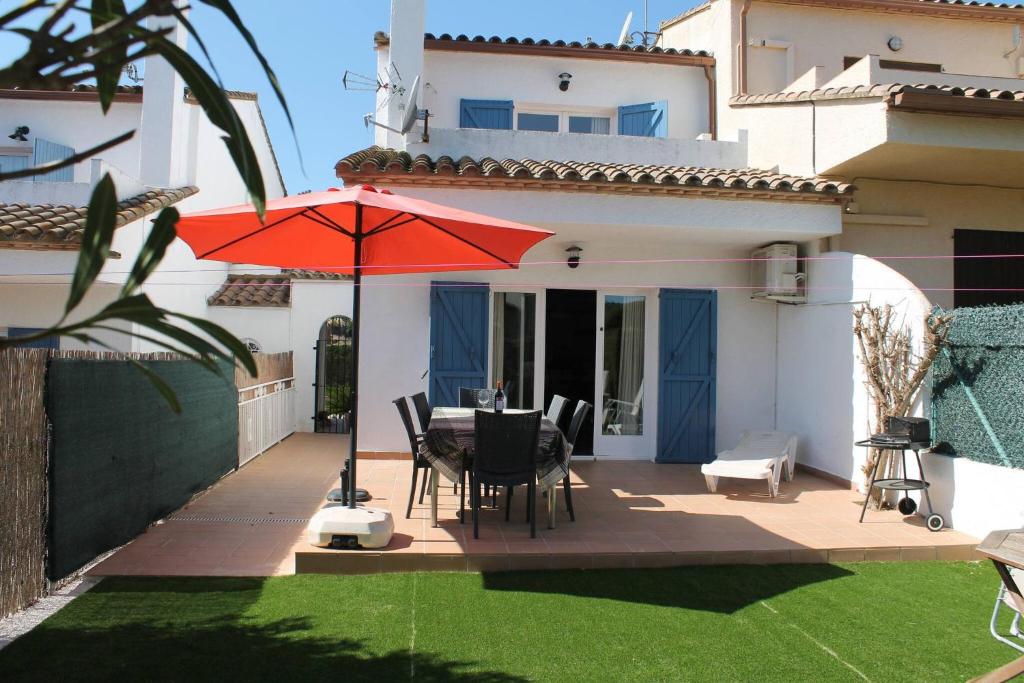 a patio with a table and a red umbrella at Breda 4a in Torroella de Montgrí
