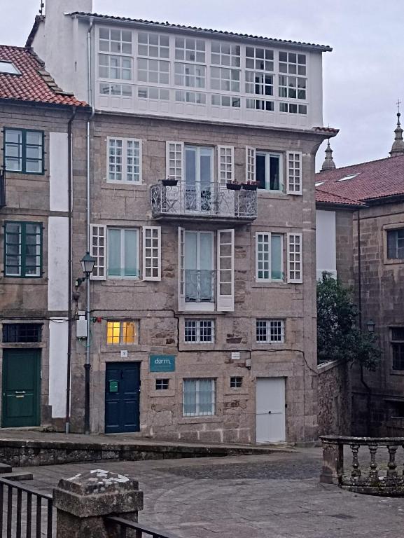 a large brick building with a balcony on top of it at Loureiros Dorm in Santiago de Compostela