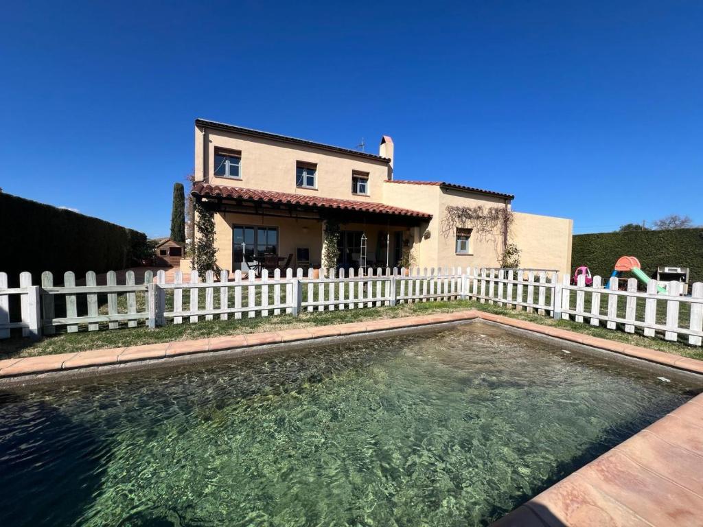 a house with a white fence and a swimming pool at Villa with privat pool La Bisbal in Vulpellach