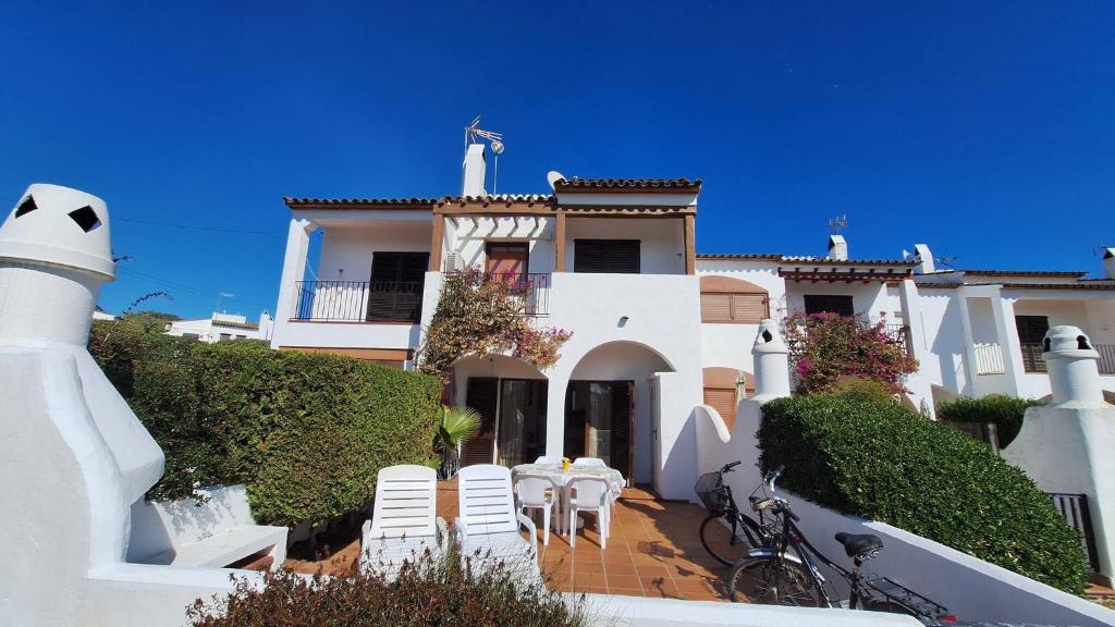 a white house with chairs and tables in front of it at Hermitage 103 in Torroella de Montgrí