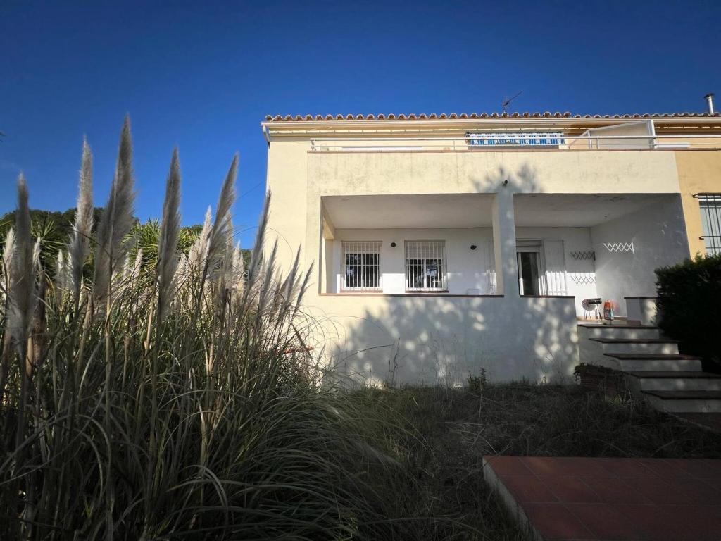a white building with stairs and grass in front of it at Casa Buckingham 27b in Torroella de Montgrí