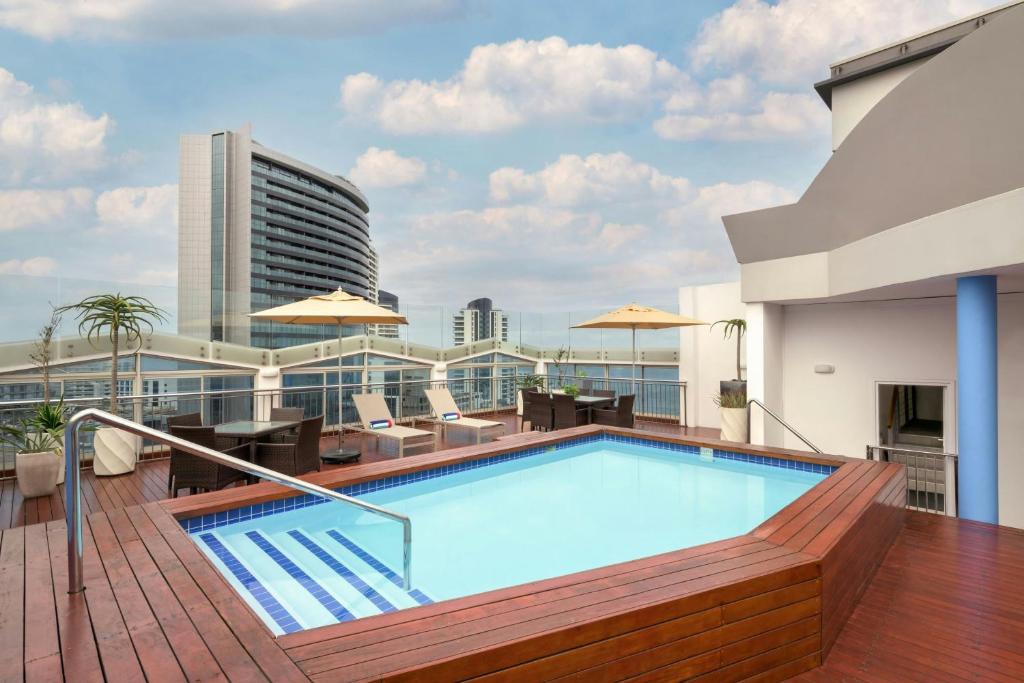 a swimming pool on the roof of a building at Protea Hotel by Marriott Durban Umhlanga in Durban