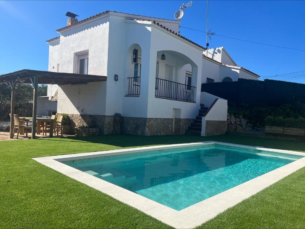 a villa with a swimming pool in front of a house at Alemanya 38 in Torroella de Montgrí