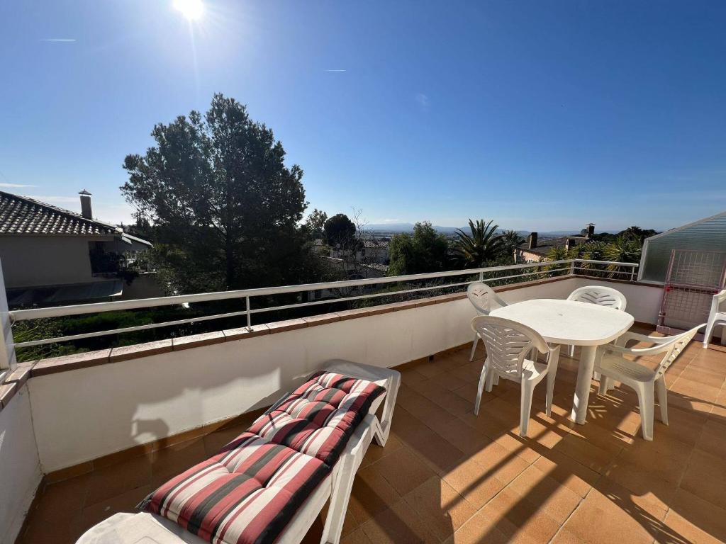 a balcony with a table and chairs on a roof at Casa Buckingham 27C in Torroella de Montgrí