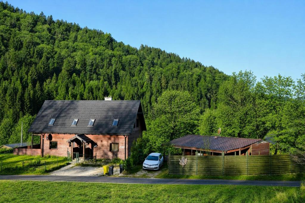 a car parked in front of a house with a mountain at Królikówka in Stronie Śląskie
