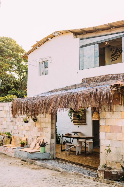 a house with a patio with a picnic table at Piano Piano hostel in Pipa