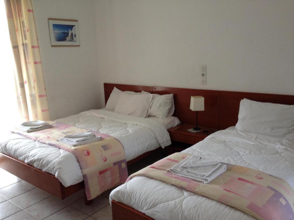 a hotel room with two beds and a lamp at Gikas Apartments Triple Studio Garden View A2 in Marmari