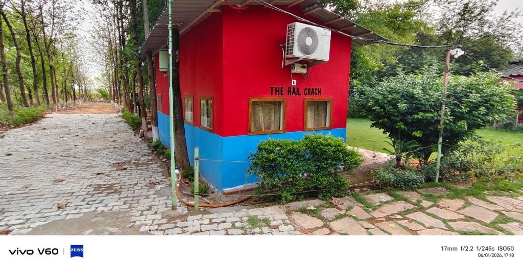 a red and blue house with a sign on it at The Rail Coach in Jhānsi