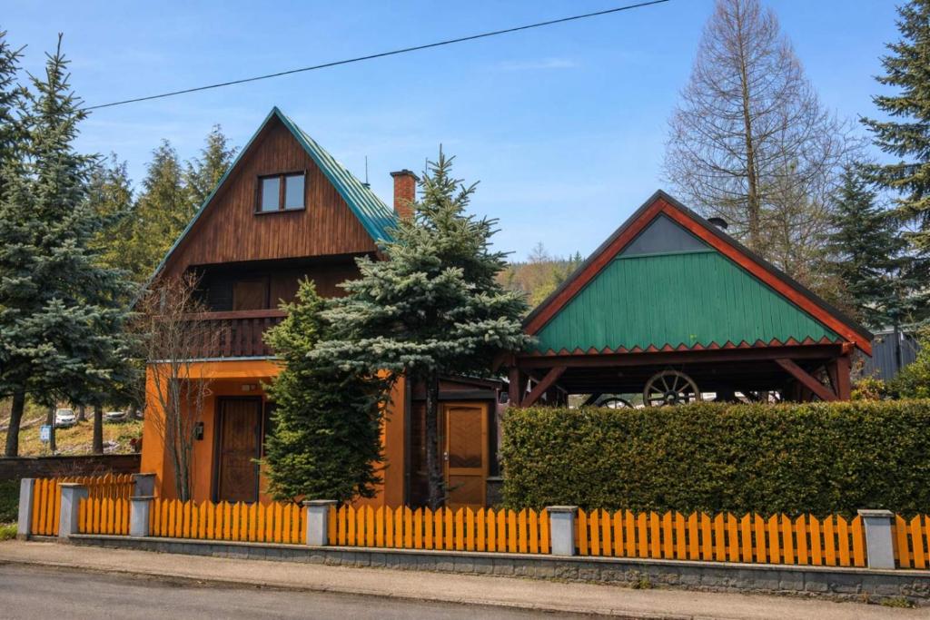 a wooden house with a green roof at Chata Kopánka in Moderštôlňa