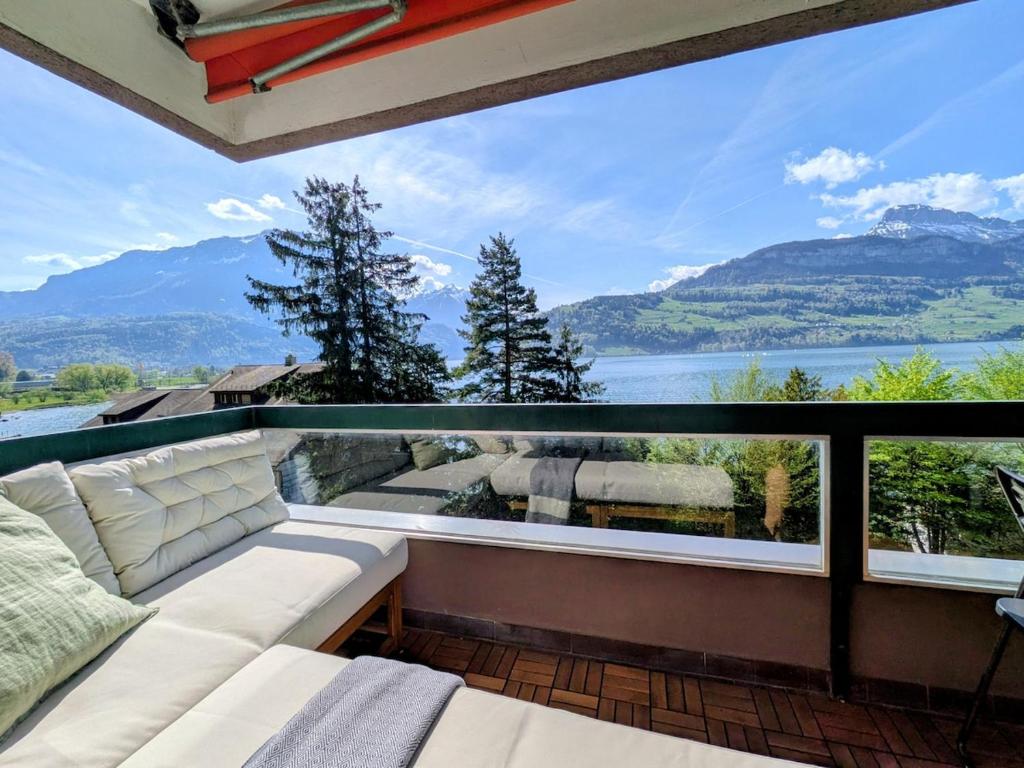 a balcony with a couch and a view of the mountains at Sunshine Suite in Ingenbohl