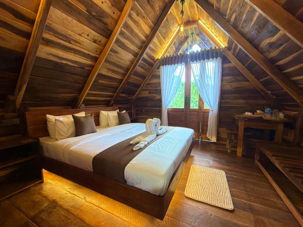 a bedroom with a bed in a wooden cabin at Mr Arachchi Luxury Cabana in Ella