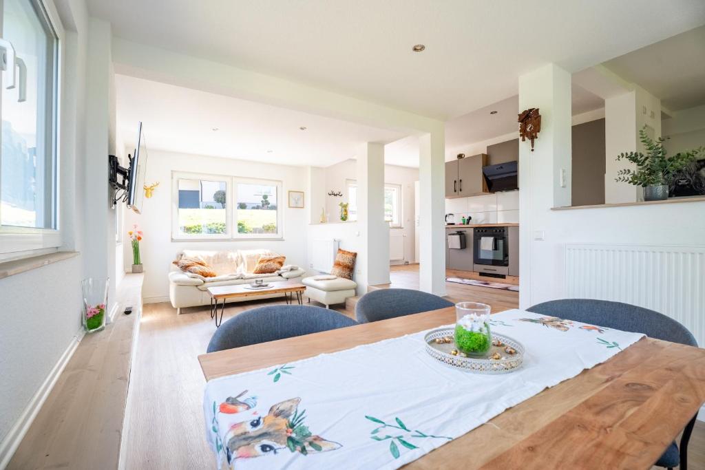 a kitchen and living room with a wooden table and chairs at Häusle Fritz in Weier