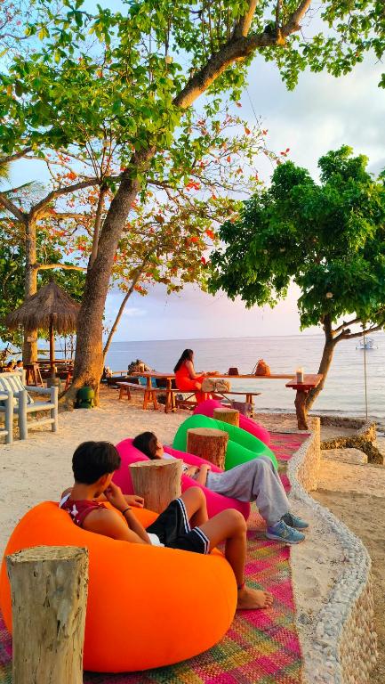 a group of people sitting on an orange couch on the beach at Republika Beach Resort in San Juan