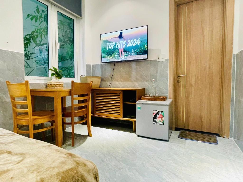 a room with a bed and a table and a tv at Tropical Homestay - Danang in Danang