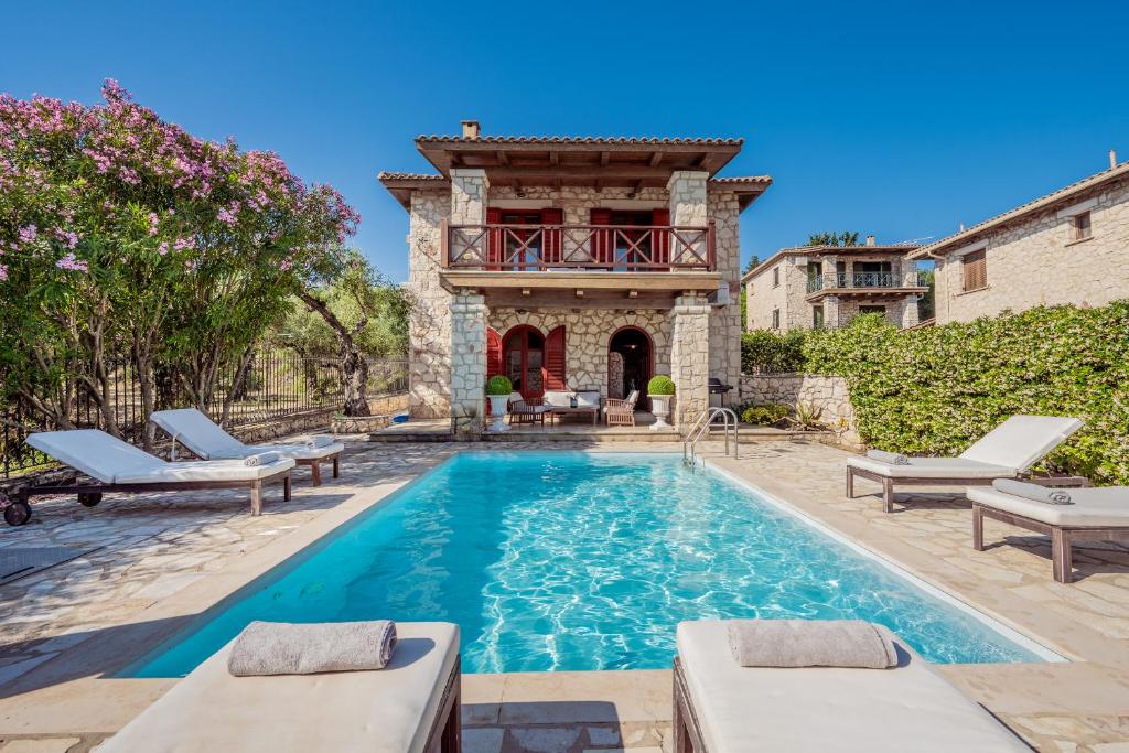 a pool in front of a building with a house at Nephele 3 bedroom villa with private pool in Akrotiri