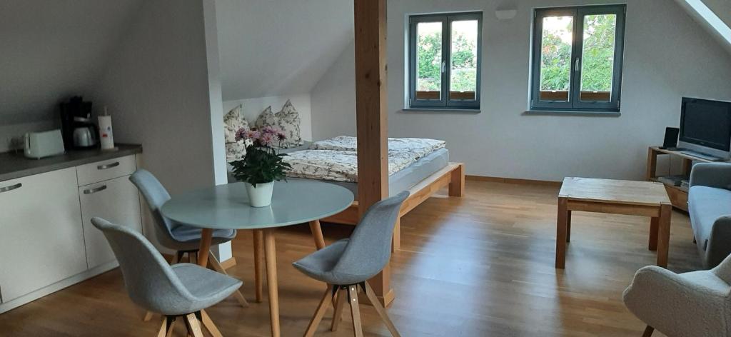 a living room with a table and chairs and a bed at Ziegfried#Ziegenhof in Radebeul