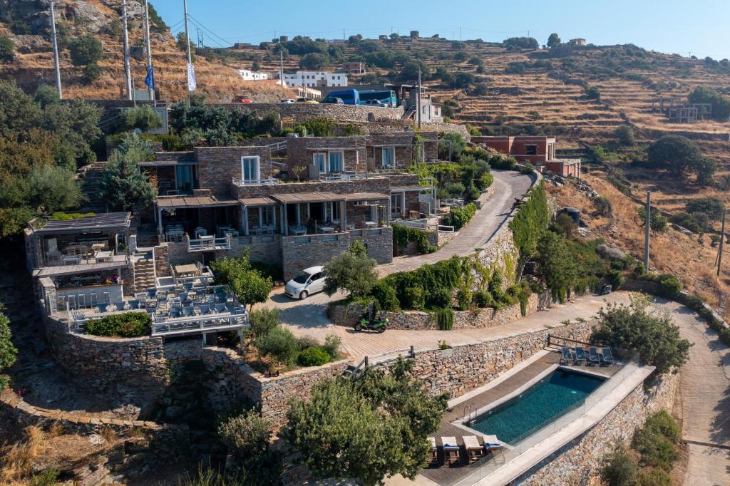 a house on a hill with a swimming pool at Kea Village Suites & Villas in Ioulis