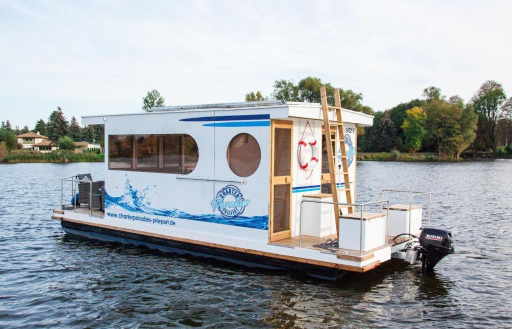 ein Hausboot, das auf dem Wasser schwimmt in der Unterkunft Lisa Boot 4 in Priepert