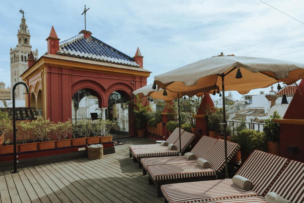 a group of chairs and umbrellas on a patio at Palacio Pinello in Seville