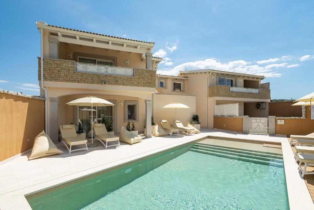 a villa with a swimming pool in front of a house at Borgo Myricae in Chia