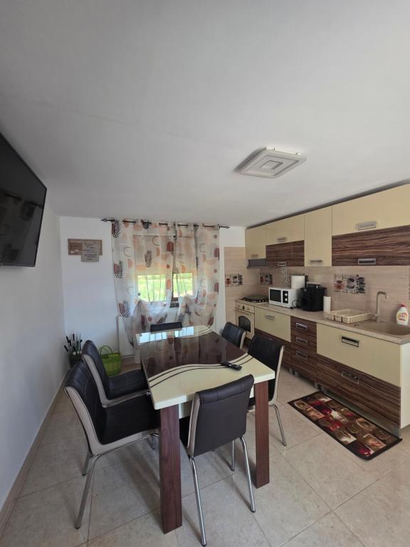 a kitchen and living room with a table and chairs at Mica căsuța in Jurilovca