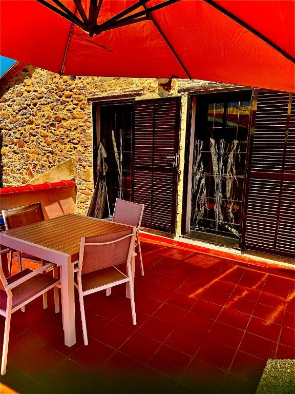 a table and chairs on a patio with a red umbrella at Antico Mulino in Imperia