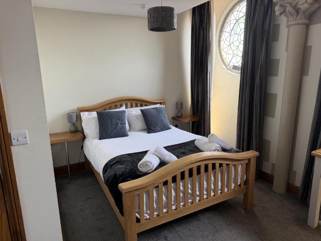 a bedroom with a bed with towels on it at St Nicholas Hotel Shrewsbury in Shrewsbury