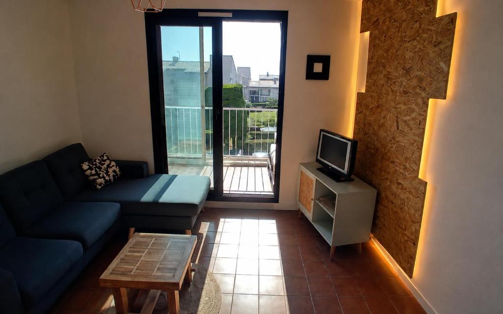 a living room with a couch and a tv at Appartement 200m plages in Six-Fours-les-Plages