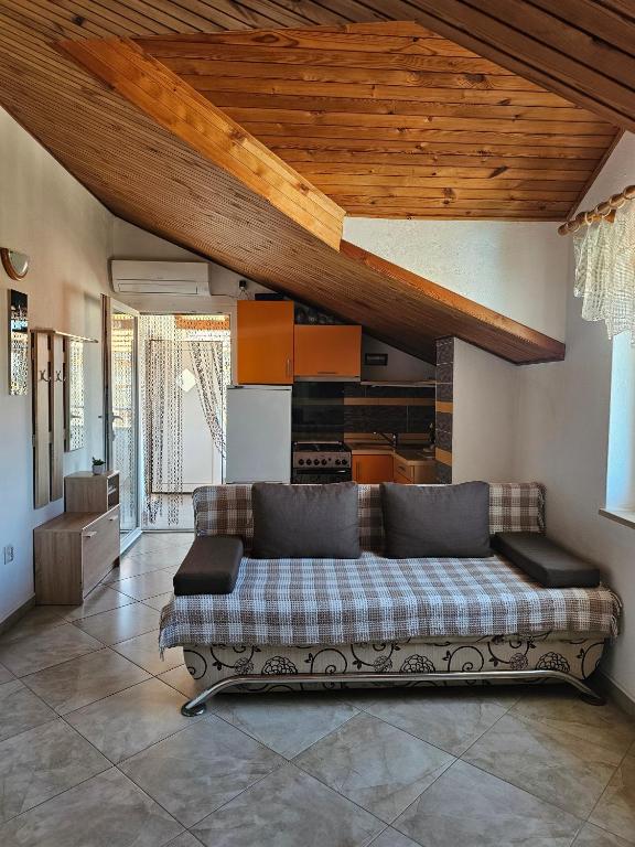 a couch in a living room with a wooden ceiling at Apartmani Banić Apartman 4 in Postira