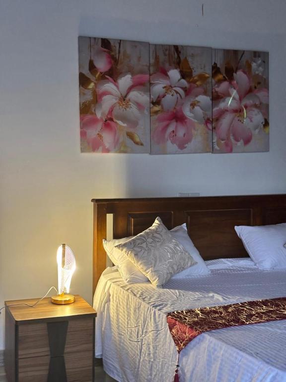 a bedroom with a bed and a table with a lamp at Peacock Forest Villa in Kosgoda