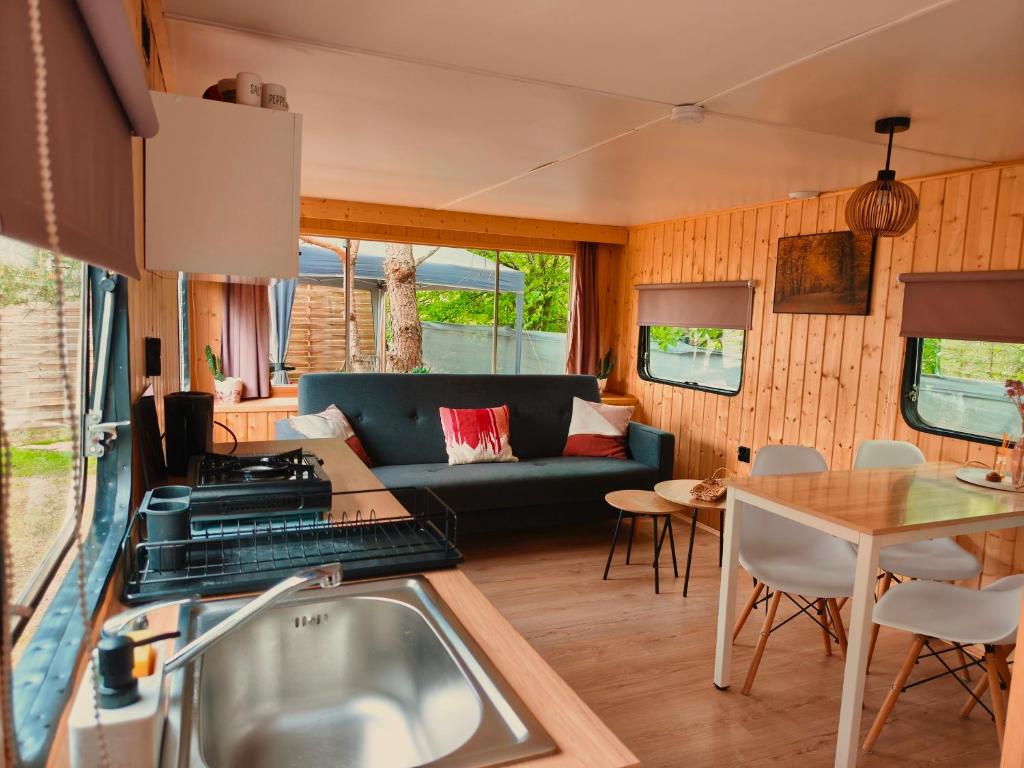 eine Küche und ein Wohnzimmer mit Sofa und Tisch in der Unterkunft Domeczek in Sulęczyno