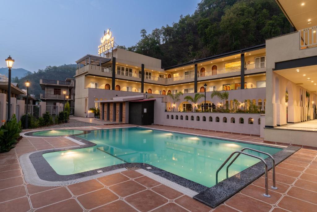 a swimming pool in front of a building at Moustache Select Rishikesh Mohanchatti in Mohan Chatti
