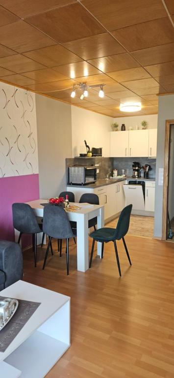 a kitchen and dining room with a table and chairs at Jasmin mit Sauna und Schwimmbad in Hohegeiß