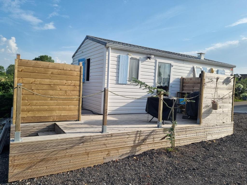 eine Holzterrasse vor einem Haus in der Unterkunft Petit logement tranquille in Wanchy-Capval