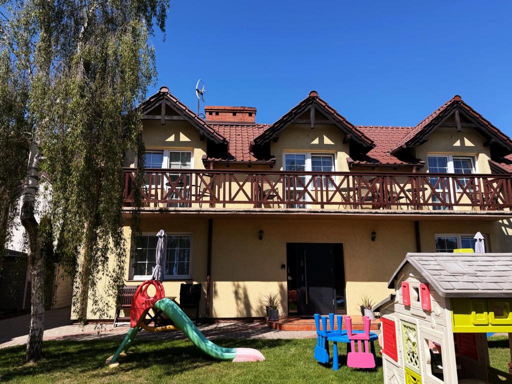 a house with a playground in front of it at Pokoje Pod Kasztanami Jantar in Jantar
